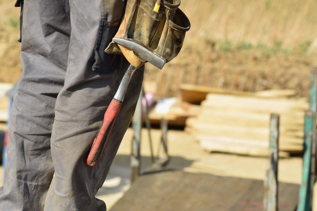 Builder carrying tools on a construction site